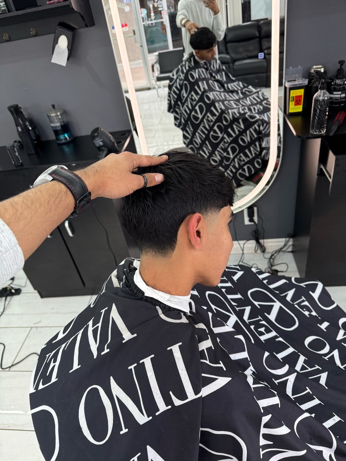 Barber finishing a taper fade in the chair