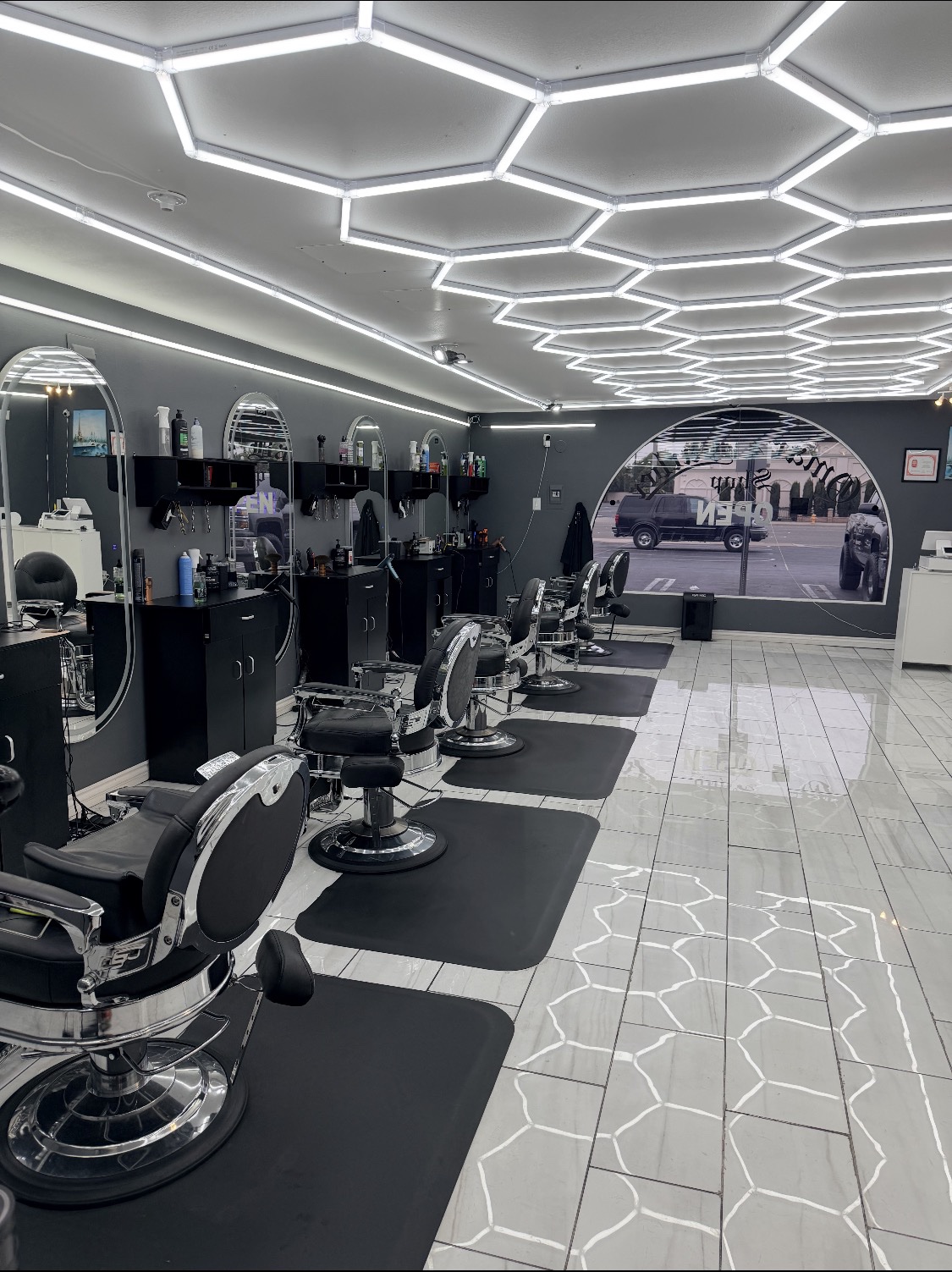 Wide view of Omar's Barbershop interior with hexagon ceiling lights
